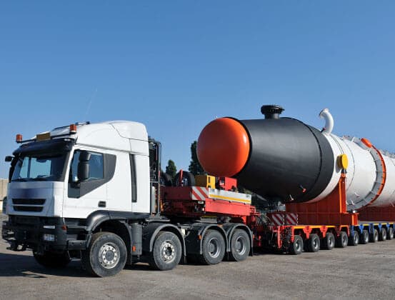 Truck hauling an oversized industrial load on a highway